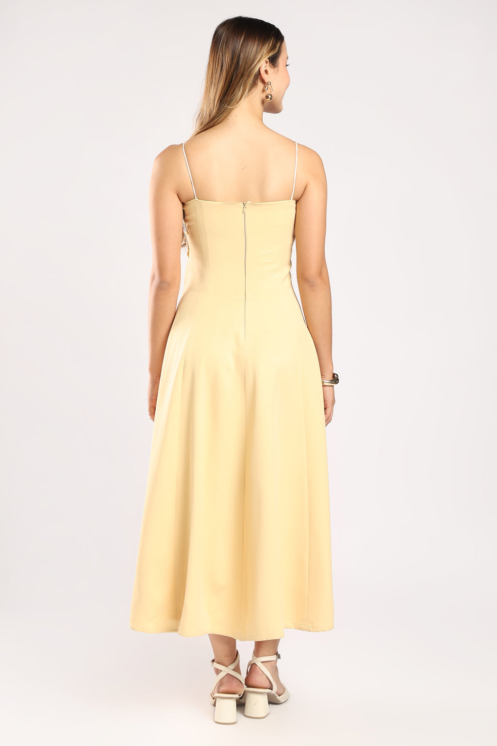 Back view of The Petal Pop Dress showing the concealed zip closure and butter yellow colour.
