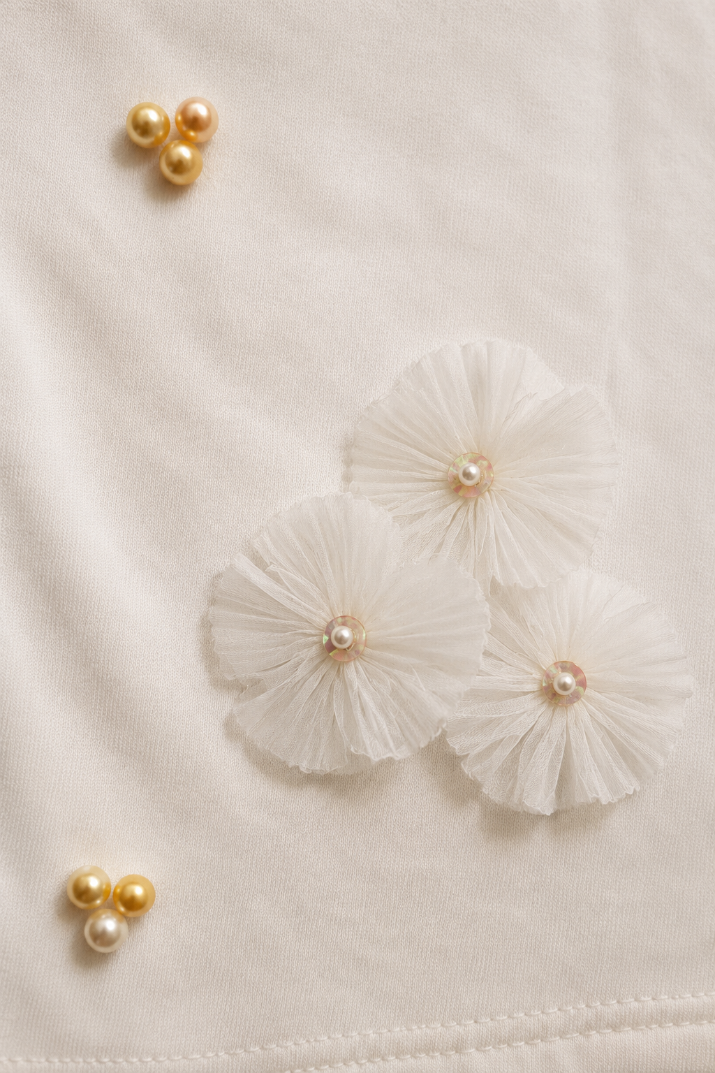 Close-up of the Midnight Pearl Women's T-Shirt highlighting the asymmetrical organza flower and pearl detailing on French Terry fabric.