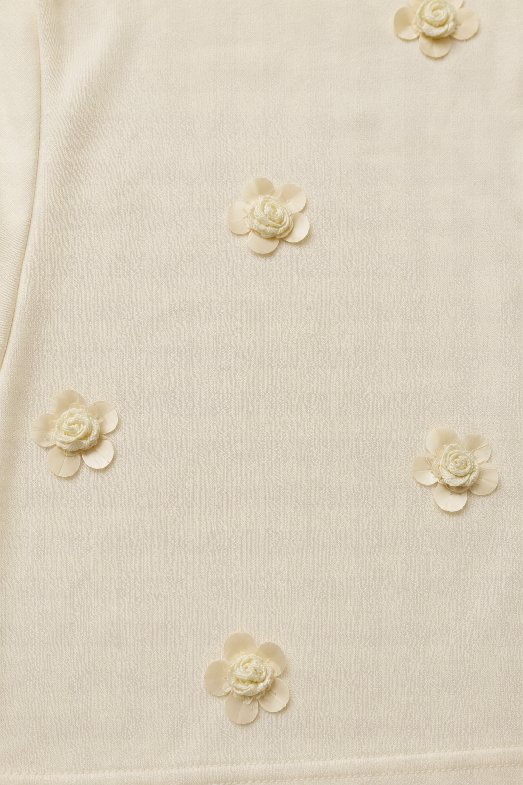 Close-up of the Soft Bloom Women's T-Shirt highlighting the handcrafted floral embellishment on French Terry fabric.