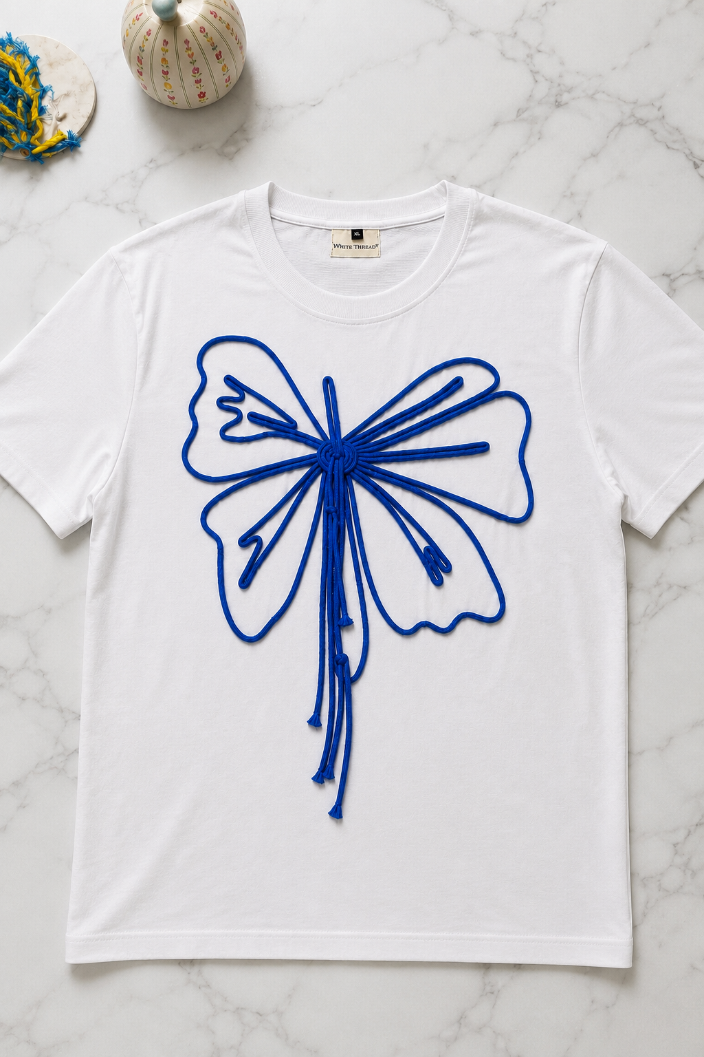 Close-up of the Butterfly Knot Women's T-Shirt highlighting the handcrafted butterfly cord detailing on French Terry fabric.