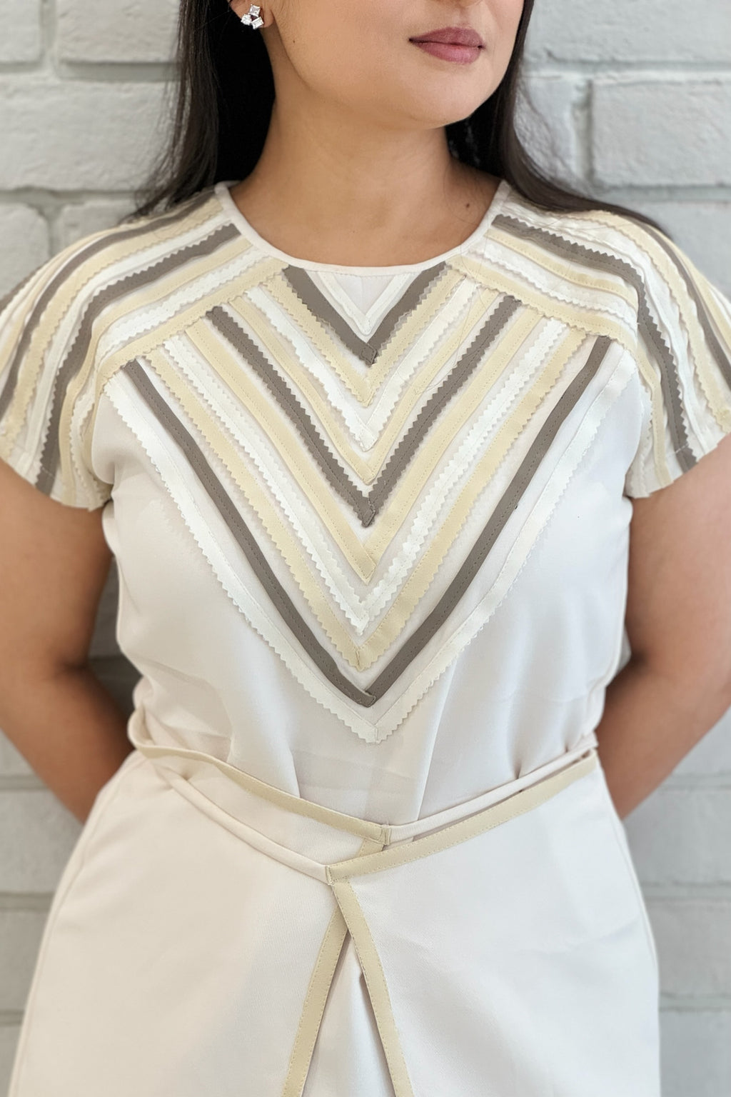 Close-up of The Charm Women's Dress highlighting the handcrafted leather detailing on imported crepe.